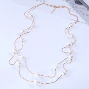 Elegant double-layered gold chain necklace with white pearls on a clean white background