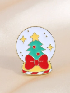Detail of Christmas tree enamel pin inside a snow globe on smooth beige silk background