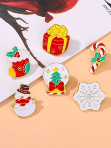 Detail of six Christmas enamel pins featuring snowman and gift box on a stylish background
