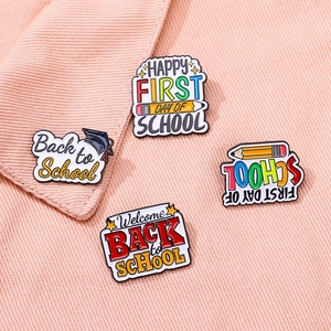 Ensemble de pin's créatifs Back to School avec crayon et toque sur fond en tissu rose