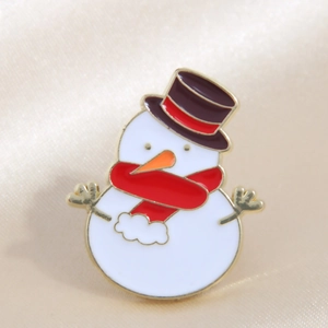 Christmas snowman enamel pin with red scarf and top hat on champagne silk background