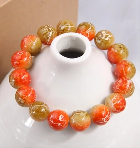 Vue détaillée du bracelet en perles bicolores orange et jaune avec texture marbrée blanche