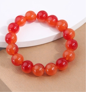 Gros plan de perles d'agate rouge polies sur un bracelet élégant pour femmes de style