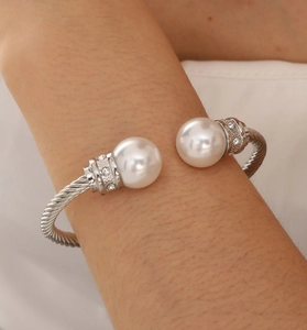 Detail of silver twisted cable cuff bracelet with large pearls and sparkling rhinestones