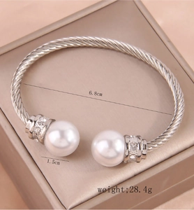 Detailed view of silver twisted cuff bracelet featuring white pearls and sparkling crystals