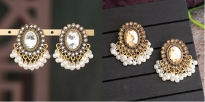 Dettaglio di orecchini vintage con pietre ovali e nappe di perle artificiali