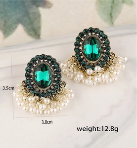 Dettaglio di orecchini vintage con gemma verde, perle e specifiche di misura