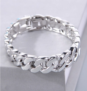 Dettaglio ravvicinato di un bracciale a maglia cubana argento con finitura lucida e chiusura