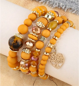 Détail macro d'un ensemble de bracelets de perles bohème avec breloque cœur arbre de vie doré