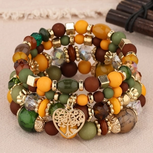 Gros plan du bracelet en perles multicouches avec un pendentif coeur doré et arbre de vie