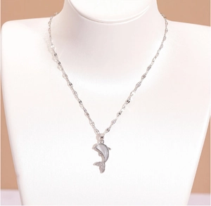 Détail du pendentif dauphin argenté avec incrustation en nacre et petites pierres brillantes
