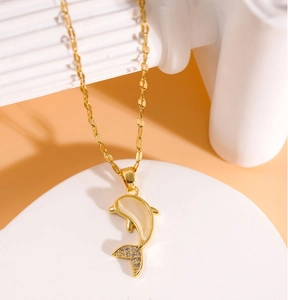 Vue macro d'un collier dauphin doré avec pierre effet opale et détails en zircon brillant