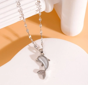 Détail du pendentif dauphin avec pierre œil de chat blanche et cristaux brillants
