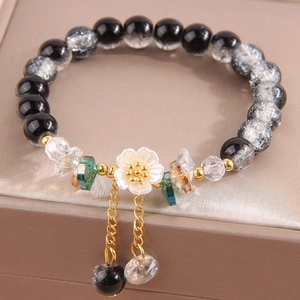 Elegant crystal bead bracelet with a white flower charm and golden fringe details
