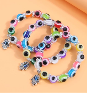 Close-up of three-layered colorful evil eye beaded bracelets with silver Hamsa Hand charms