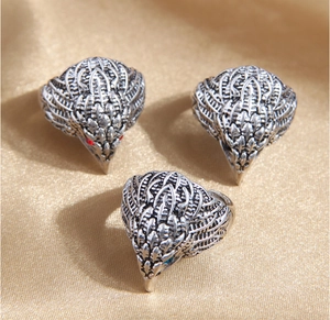 Detailed close-up of vintage silver eagle rings with red and blue gemstone eyes