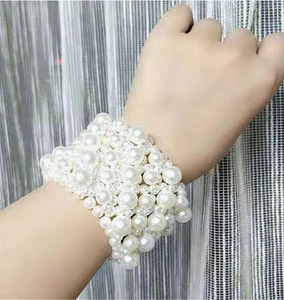 Detail of wide multi-layer pearl stretch bracelet on wrist with textured bead finish