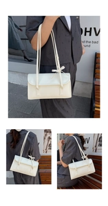 Détail du sac baguette crème avec des nœuds élégants sur la bandoulière réglable