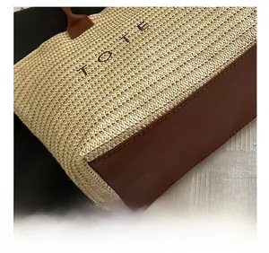 Detail shot of the precise leather stitching and woven straw texture on the large tote bag