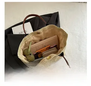 Interior view showing large storage capacity of a beige woven tote bag with daily items