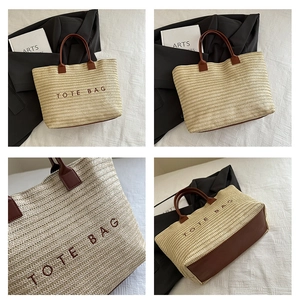 Macro view of woven tote bag with brown embroidery and faux leather handle detail