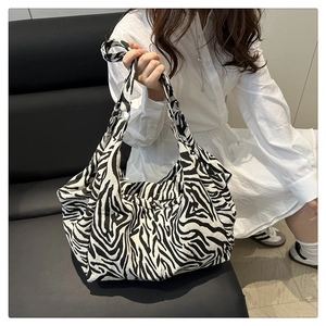 Gros plan du grand sac cabas à motif zèbre noir et blanc dans un décor minimaliste