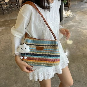 Striped straw bucket bag with brown leather straps and a white plush cloud charm