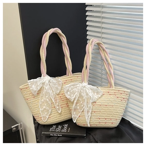 Detail of woven beach tote set with colorful speckles and pink rope handles with white bows