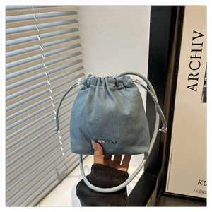 Détail du sac seau en jean bleu avec cordon de serrage, logo JINGPIN et bandoulière