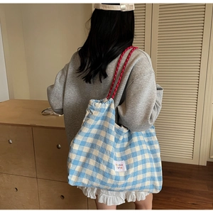 Détail du grand sac cabas à carreaux bleus avec anses à cordon rose et étiquette