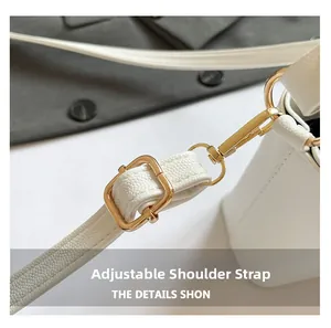Detail of adjustable leather strap with premium gold metal hardware on white handbag