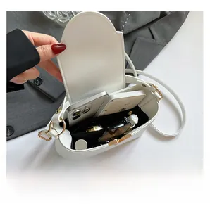 Interior view showing large capacity for phones and cosmetics in a white crossbody bag