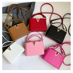 Detailed view of fashionable mini bucket bags in multiple colors with V-shaped metal hardware