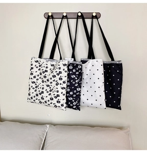 Detailed view of canvas tote bags with floral patterns and delicate white lace trim