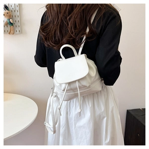 Model back view of white leather mini backpack with flap closure and slim straps