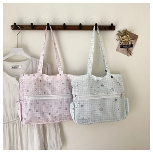 Detail of pink and mint green plaid canvas tote bags with transparent PVC star pockets