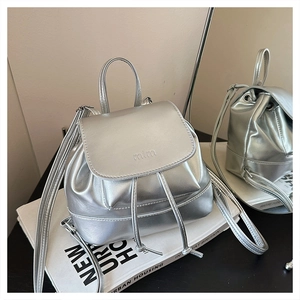 Close-up of metallic silver mini backpack with drawstring closure and logo detail