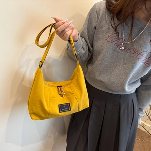 Minimalist bright yellow hobo shoulder bag with adjustable strap and logo detail