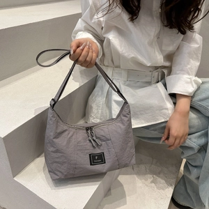 Minimalist grey nylon shoulder bag with adjustable strap for a stylish casual daily look