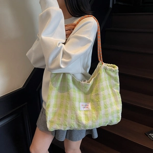 Minimalist green plaid canvas tote bag with orange rope straps for casual daily use