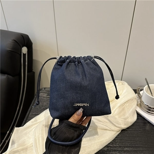 Sac seau minimaliste en denim bleu foncé avec logo argenté pour un usage quotidien