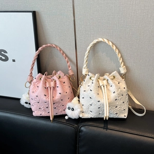 Bow embroidered drawstring bucket bags in pink and white with woven handle and plush charm