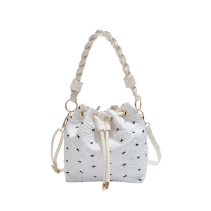 White bow-knot pleated bucket bag with a woven handle and long shoulder strap
