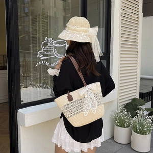 Borsa tote in paglia beige con fiocco in pizzo e manici in pelle per look da spiaggia