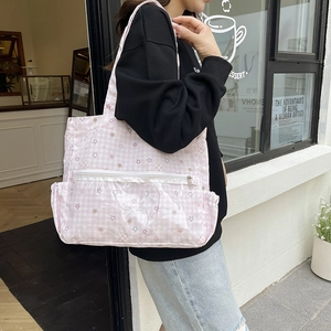 Pink checkered canvas tote bag with white stars and clear PVC pocket in outdoor view