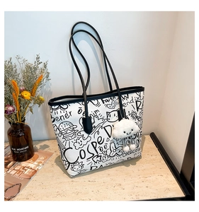 Detail of white canvas tote bag with black graffiti print and plush cloud charm