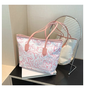 Detail of white canvas tote bag featuring pink graffiti art and a stylish cat illustration