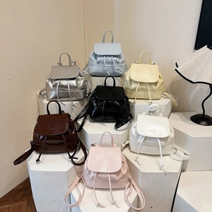 Mini synthetic leather backpacks in seven colors on display stands for spring 2025
