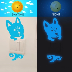 Luminous blue puppy wall sticker for light switches showing day and night glowing effect