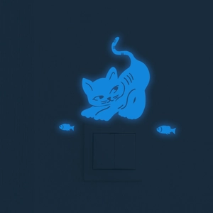 Luminous blue cat and fish wall decals glowing on switch plate in the dark room